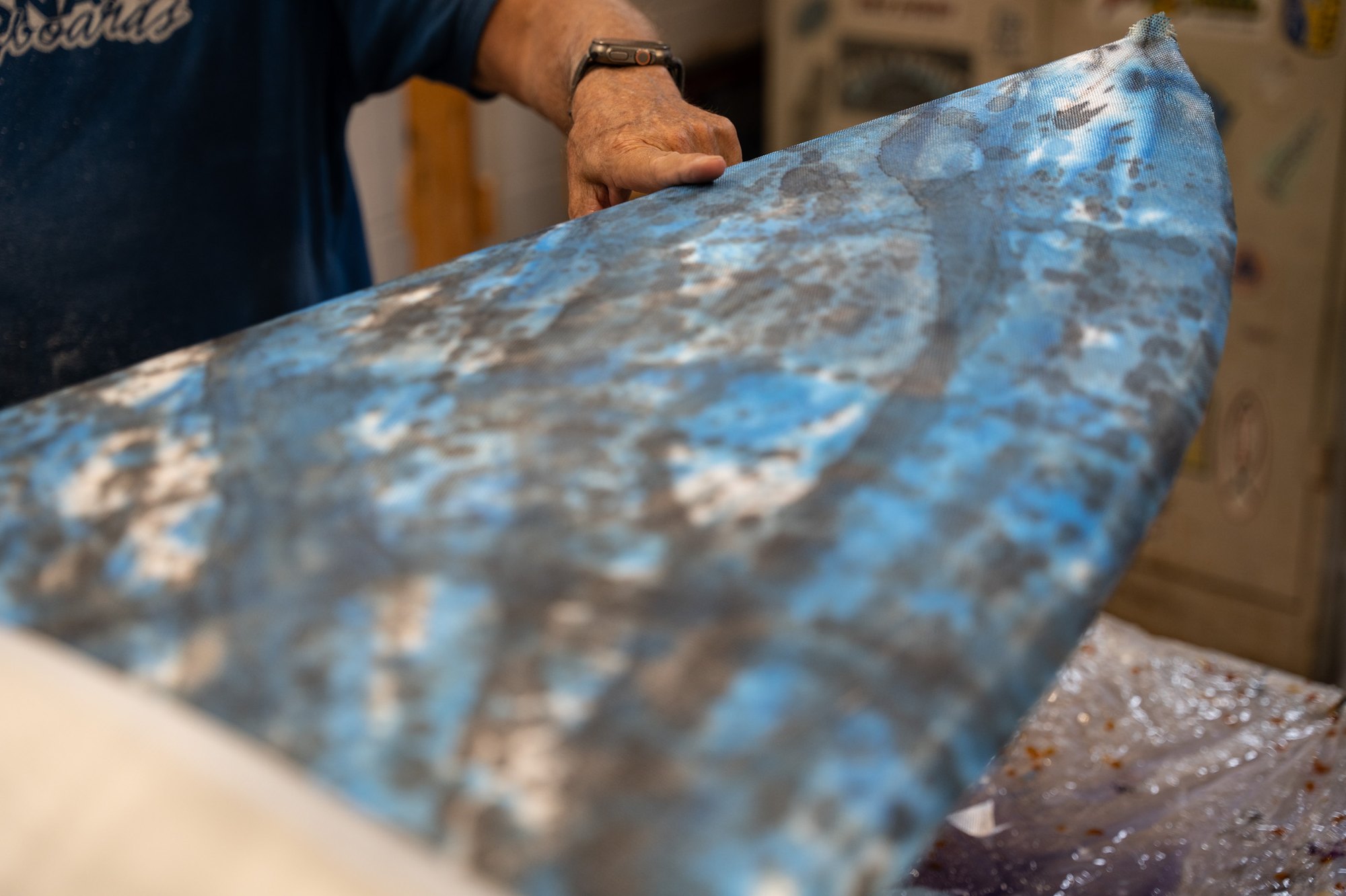 A sheet of hand tie-dyed fiberglass cloth held up in the glassing room