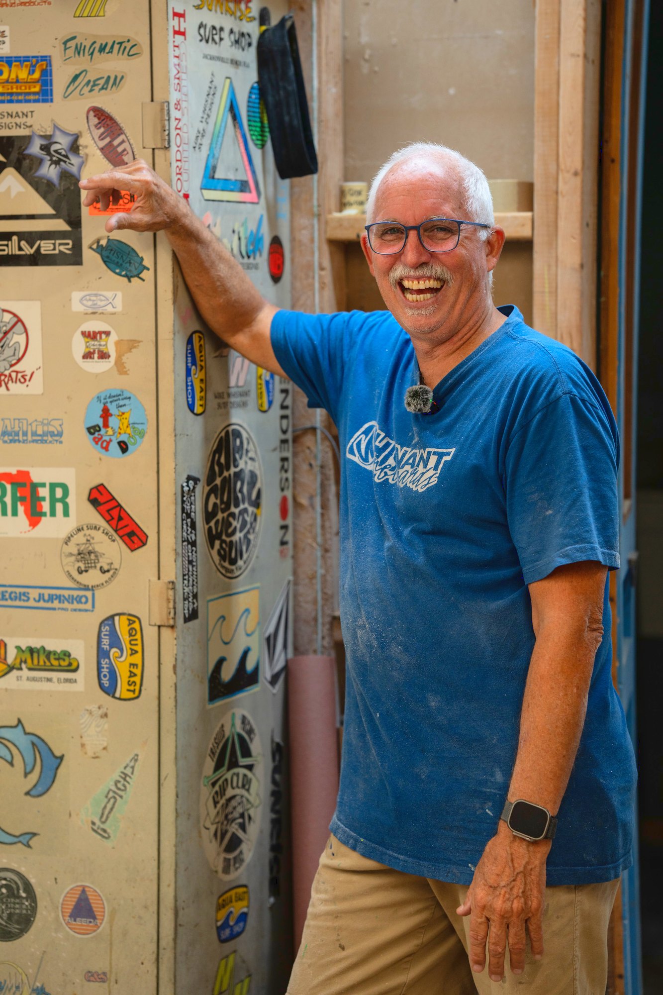 Mike Whisnant pointing to a bare spot on his sticker-covered shop cabinet