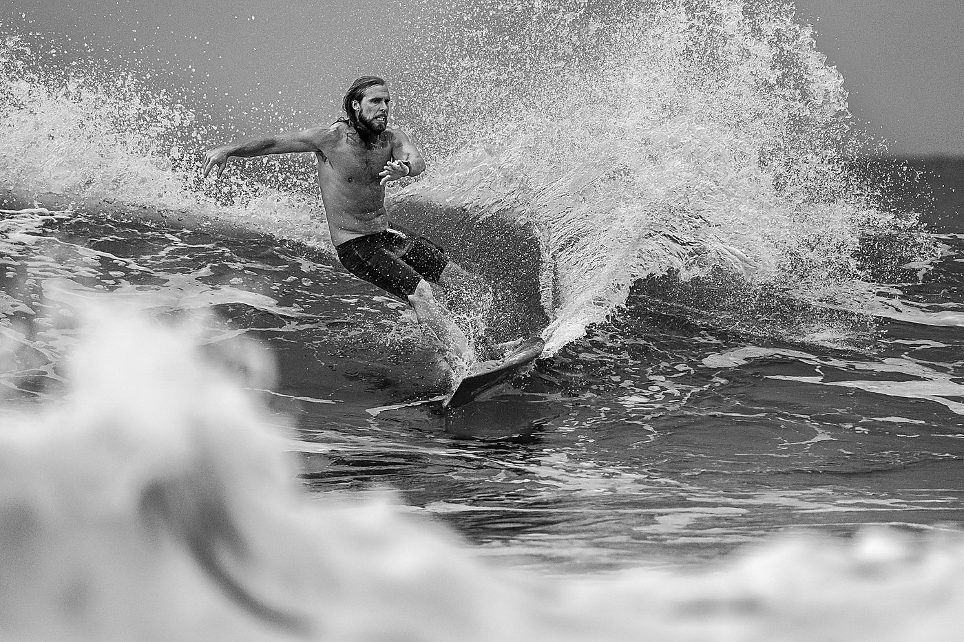 Black and white photo of a surfer in a flowing carve