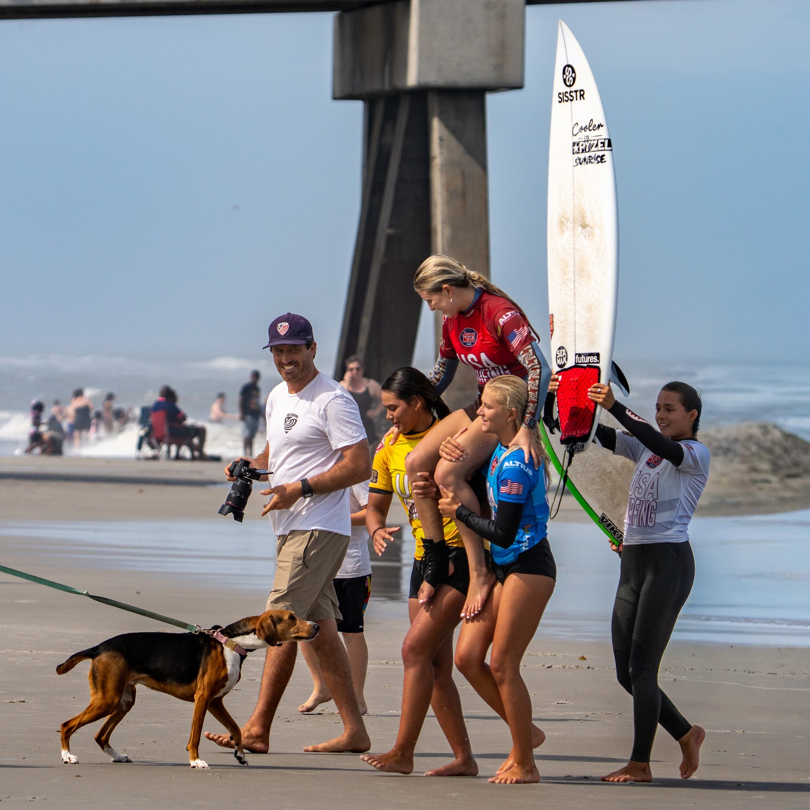 Lanea Mons carried by teammates at Jacksonville Beach pier