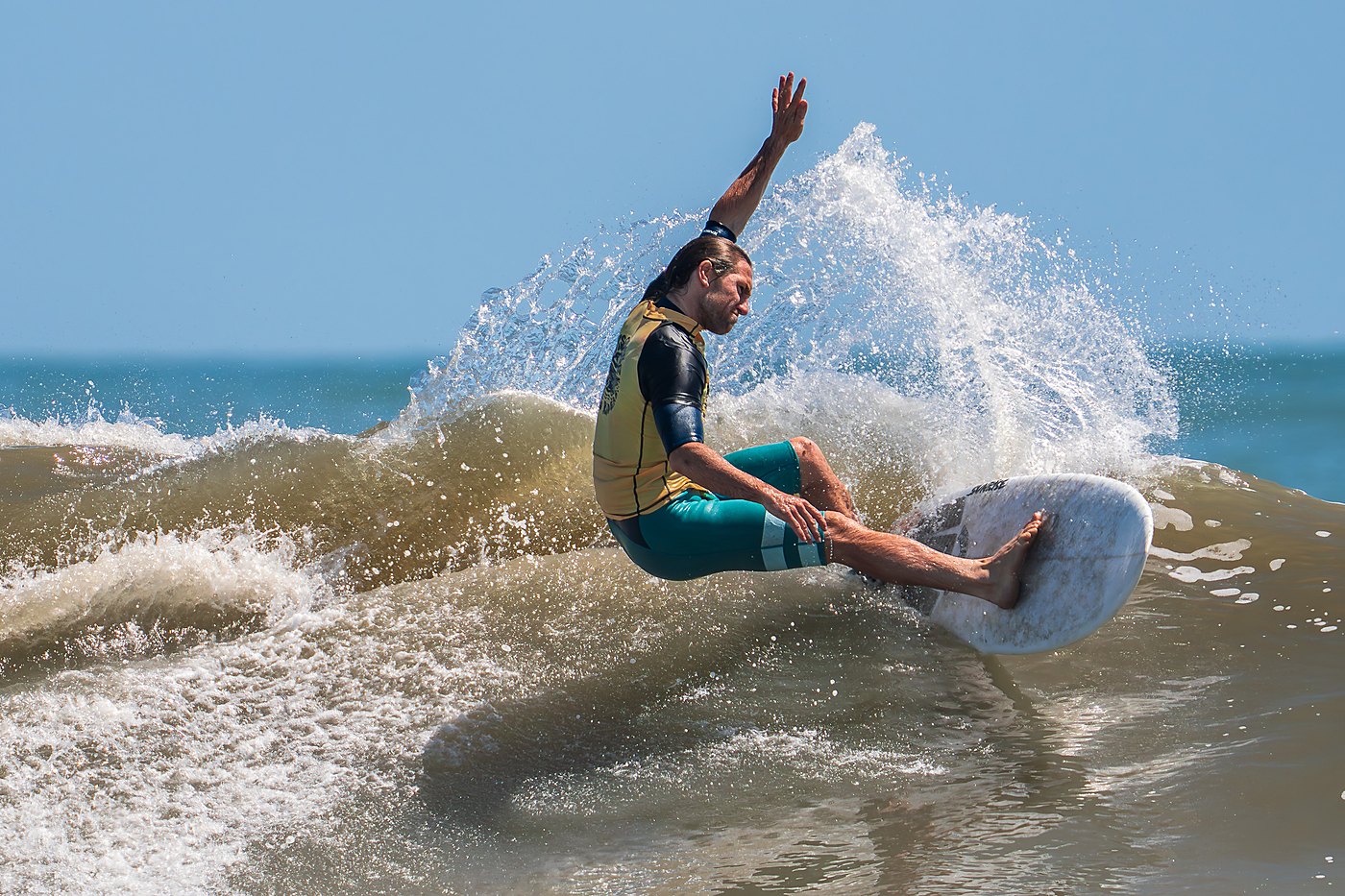 Surfer performing a layback snap on a wave