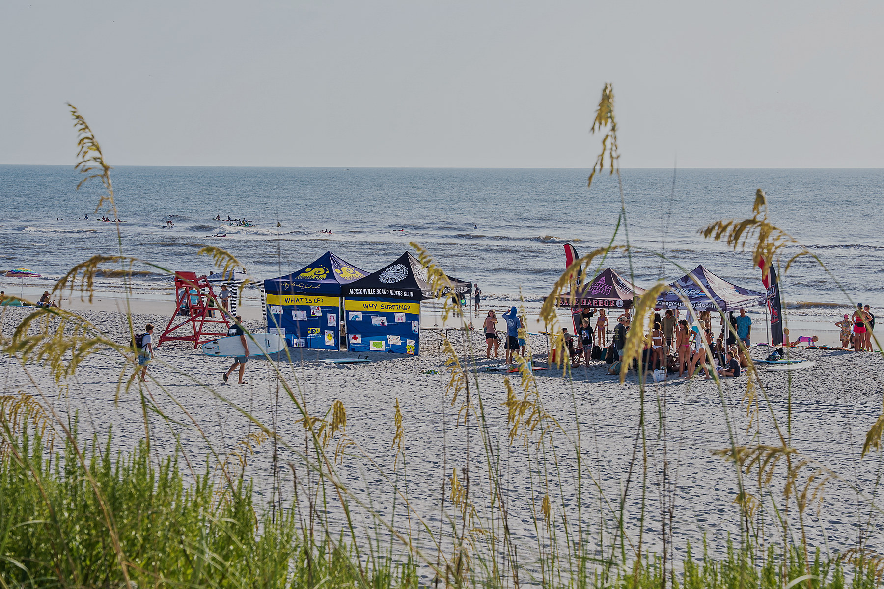 Two tents on the sand, one asking what cystic fibrosis is, the other asking why surfing. Between them, the ocean the whole morning is built around.