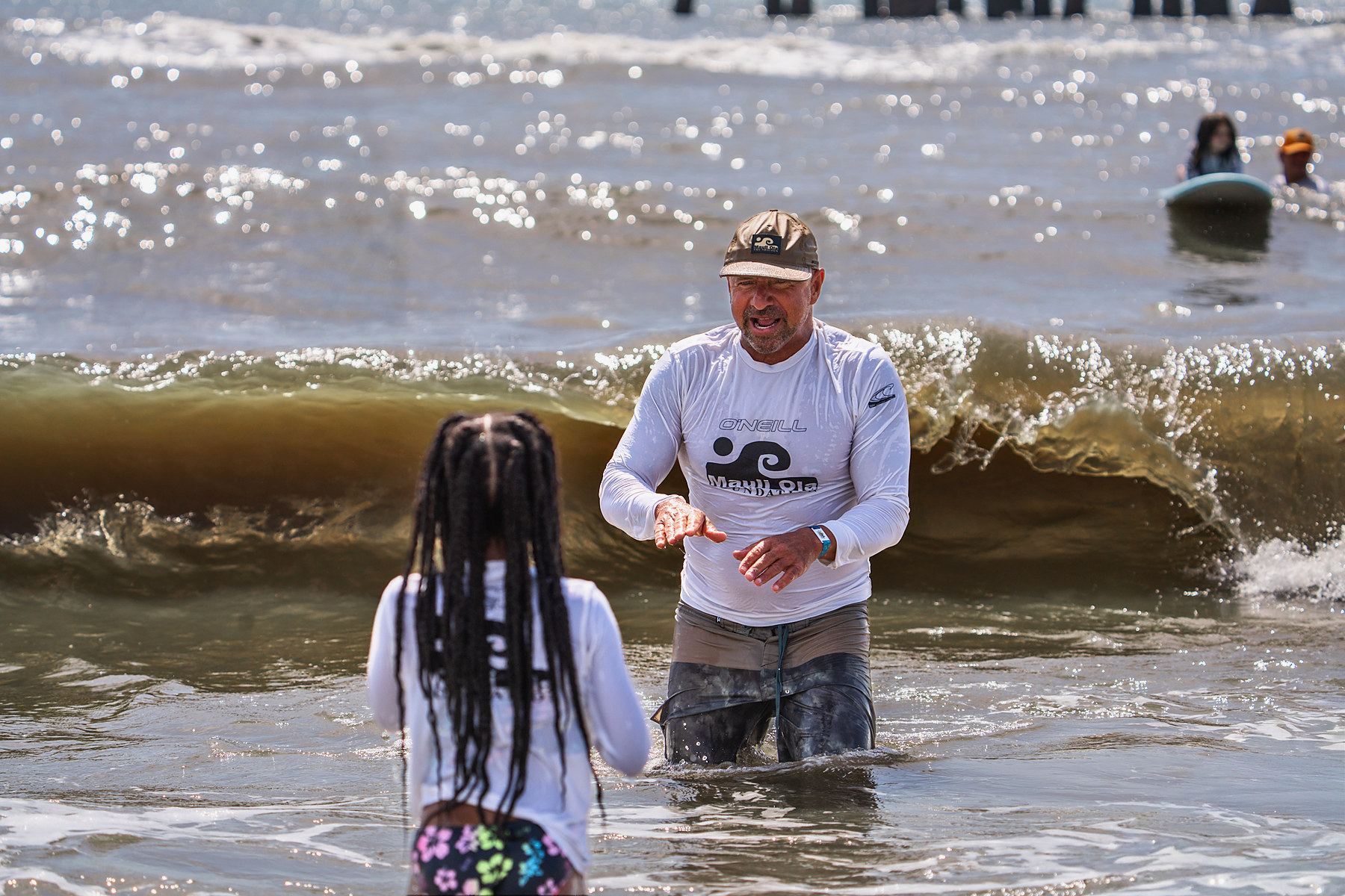 Instruction in waist-deep water, a wave stacking up behind. The last thing said before a ride is usually about where to put your feet.
