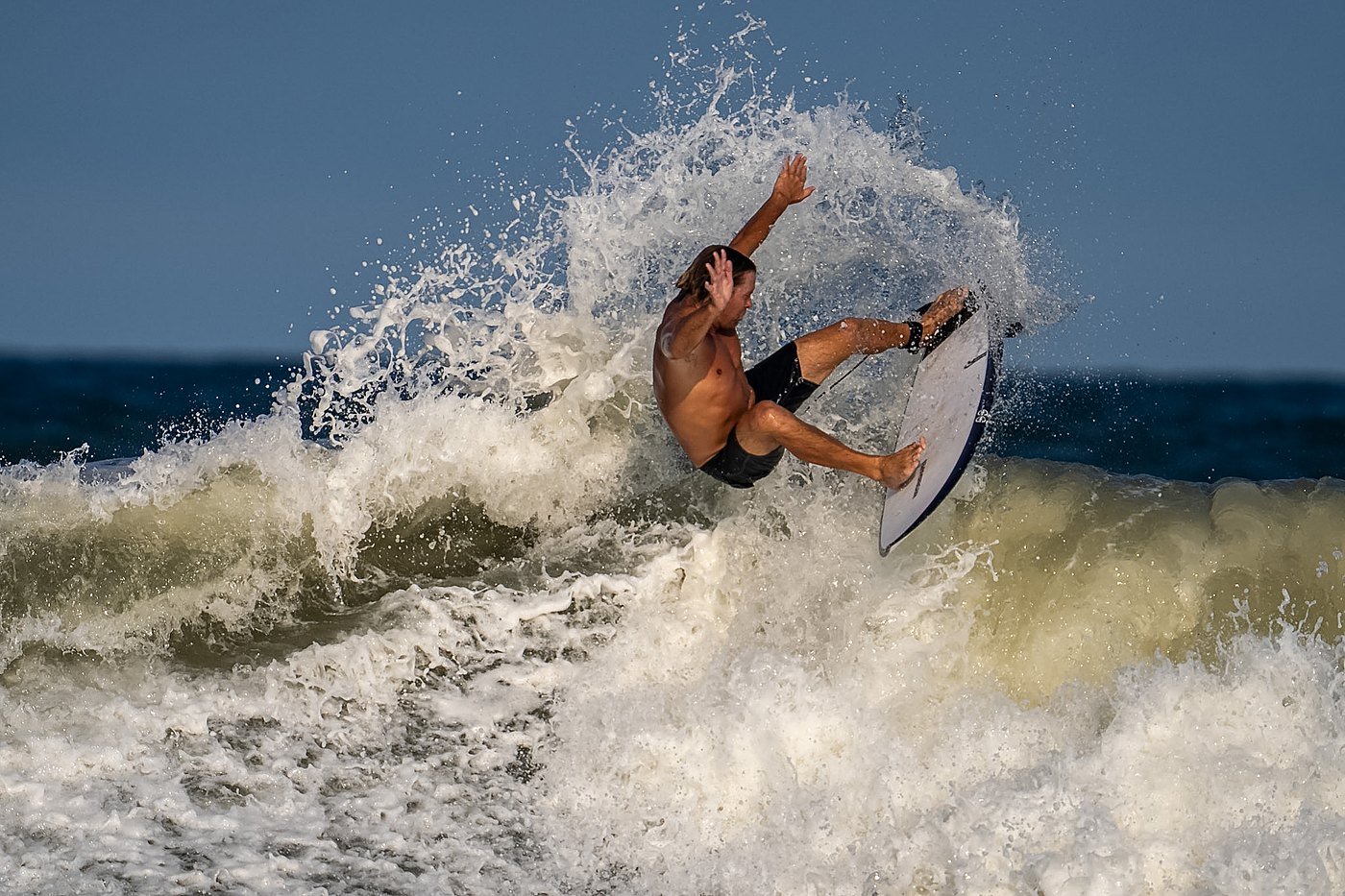 Surfer hitting the lip vertically as the wave breaks