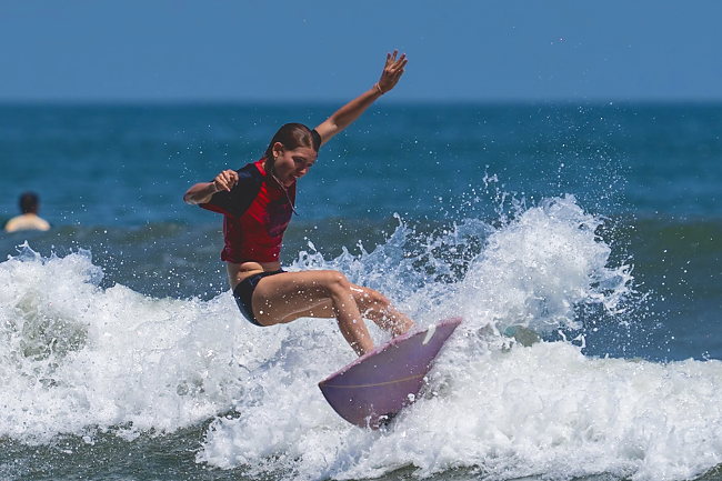 A surfer launches off the lip, board and spray in the air.