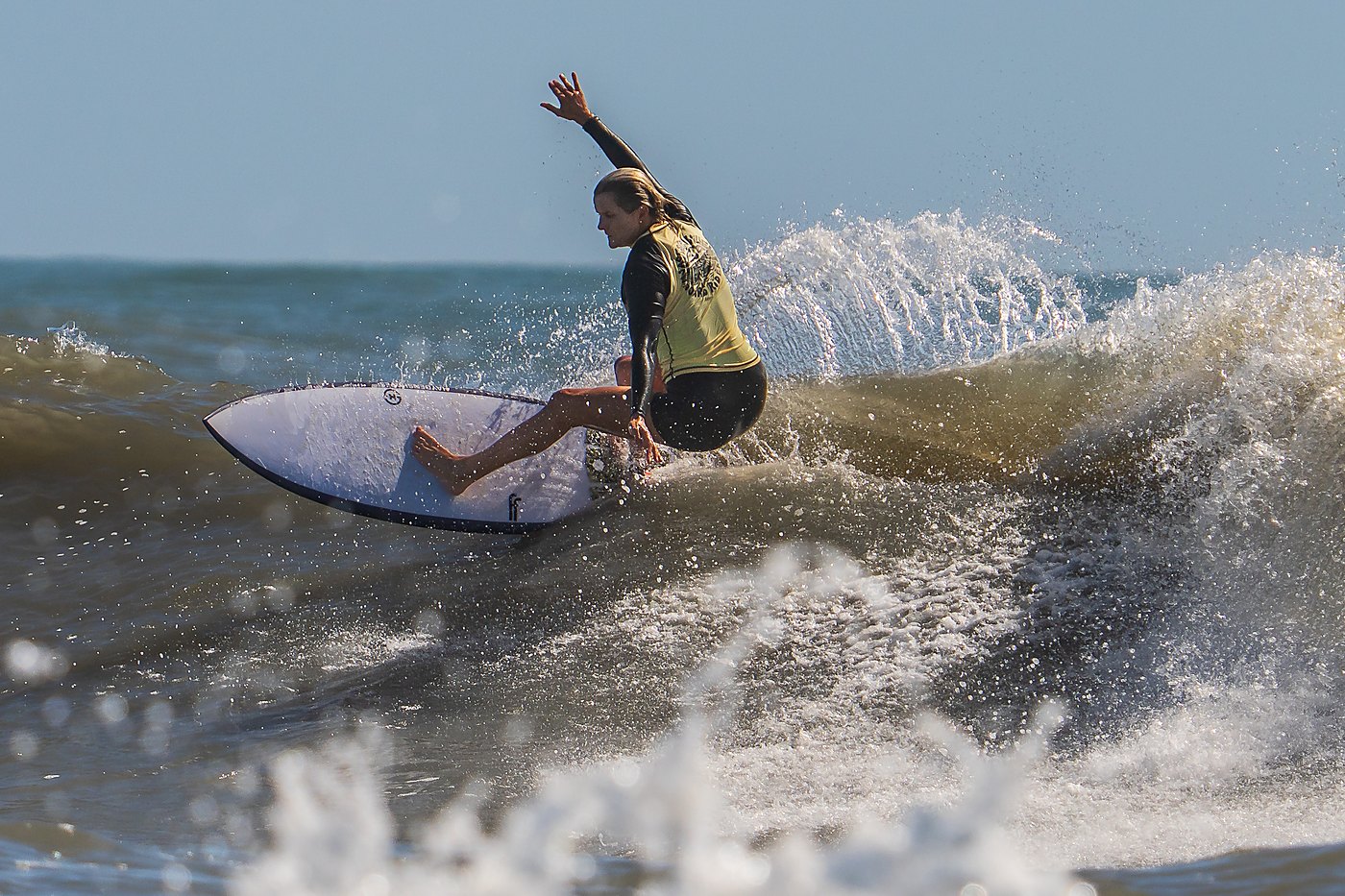 Surfer performing a vertical re-entry off the lip